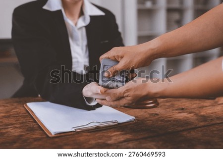 Person receiving a bundle of us dollar bills, representing illegal transactions and financial misconduct