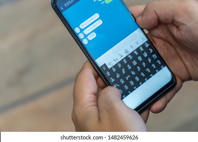 Person receiving and sending encrypted messages on a mobile phone. Alien message concept.