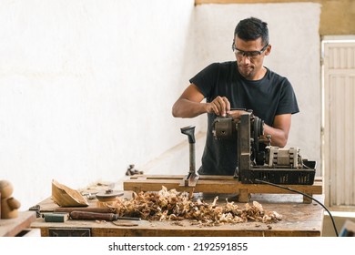 Person repairing a machine in his workshop. Carpenter performing maintenance on his tools. Latino worker doing his daily chores. Enterprising man performing his daily trades - Powered by Shutterstock