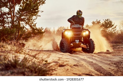 Person riding ATV in sand dunes making a turn in the sand