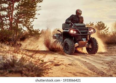 Person riding ATV in sand dunes making a turn in the sand 