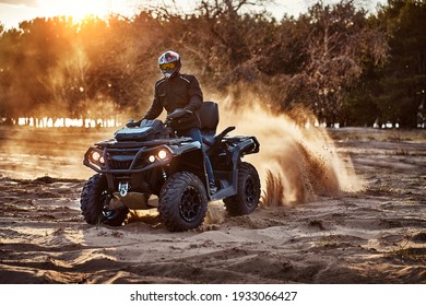 Person riding ATV in sand dunes making a turn in the sand 