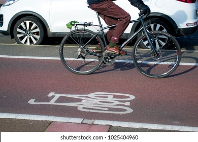 Person Riding A Bicycle On A Cycle Path Next To Cars