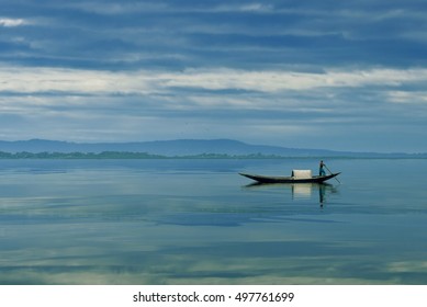 person riding boat in the river of bangladesh on dreamy cloudy day