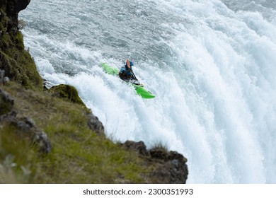 a person is riding a kayak down the beautiful Goðafoss(godafoss waterfall), Fossholl, Iceland. 