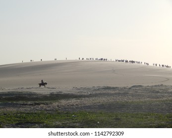 Person riding in the middle of the dune in a beautiful desert landscape