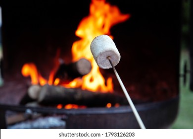 Person Roasting Over Fire Flames A Marshmallows Over Campfire At Night On A Summer Day, For Smores Or Snack Closeup