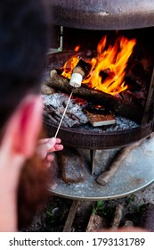 Person Roasting Over Fire Flames A Marshmallows Over Campfire At Night On A Summer Day, For Smores Or Snack Closeup