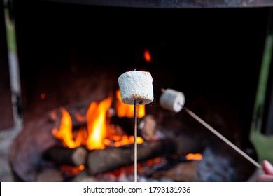 Person Roasting Over Fire Flames A Marshmallows Over Campfire At Night On A Summer Day, For Smores Or Snack Closeup