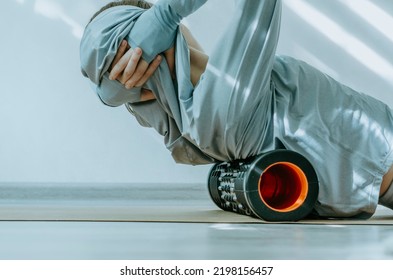 Person Rolling Back On A Foam Massage Roller To Release Tension In Back Muscles. 