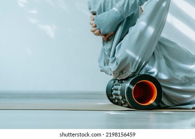 Person Rolling Back On A Foam Massage Roller To Release Tension In Back Muscles. 