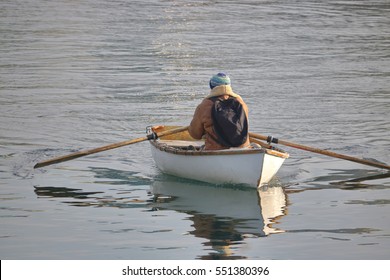 A person rows a wooden rowboat/Rowing a Wooden Rowboat/A person rows a wooden rowboat. 