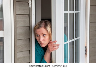 Person Is Scared Looking Out Their Front Door Of Their House 