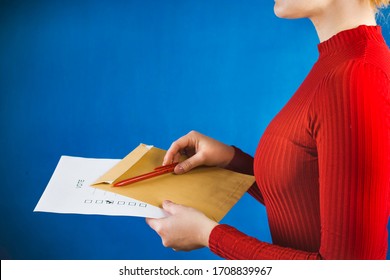 A person sends a letter with a correspondence voting card. Elections during the quarantine of the coronavirus epidemic. 
Blue background
 - Shutterstock ID 1708839967