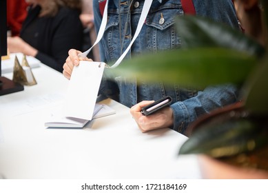 Person Showing Badge In Registration Desk For Conference