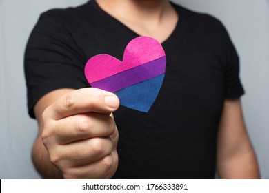 person showing a bisexual heart