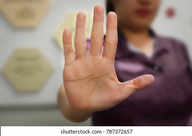 A person showing an open hand signal that means stop or wait isolated on a blurred background