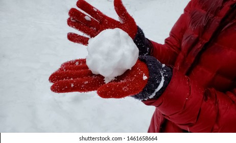 Person showing snowball to camera, winter entertainment, playing active games