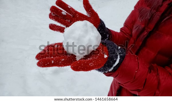 Person showing snowball to camera, winter entertainment, playing active games