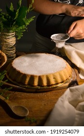 Person Sifting Powdered Sugar Into Cake