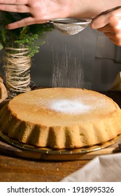 Person Sifting Powdered Sugar On Cake