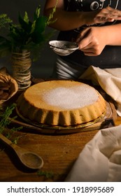 Person Sifting Powdered Sugar On Cake