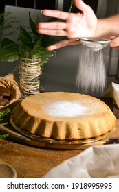 Person Sifting Powdered Sugar On Cake