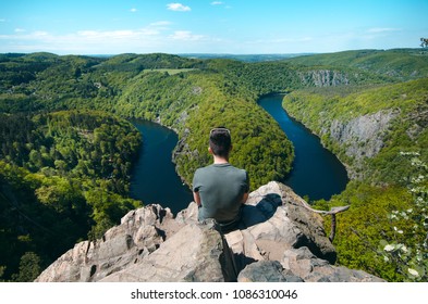 Person sitting on a peak and relaxing. Nature of Czech Republic and sightseeing called Vyhlídka Máj. Vltava river. 
