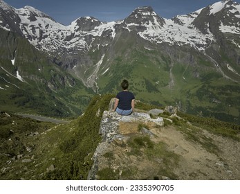  a person sitting on a rock overlooking a valley and mountains. .  - Powered by Shutterstock