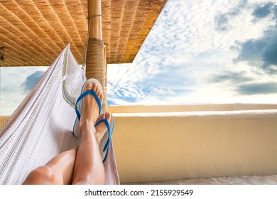 A person sleeping on a hammock on sunnyday, holiday and vacation concept, wearing slipper and taking a nap