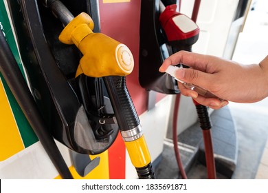 Person Spray Sanitizer Onto Fuel Gas Pump Before Using As Protection Against Germs In New Normal