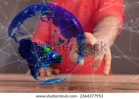 A person is standing in front of a transparent globe, with a variety of colored dots and lines radiating outward from the center of the globe