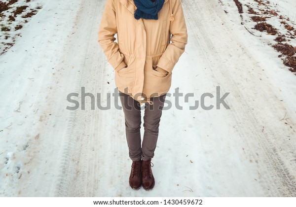 Person standing on an\
icy road in winter