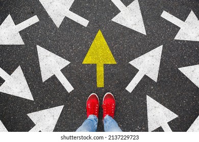Person standing on the road to future life with many direction sign point in different ways and only yellow one. Decision making is very hard, but you have a choice and right way - Shutterstock ID 2137229723