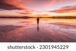 Person standing in salt lake during colorful sunset, epic mood beautiful travel photo