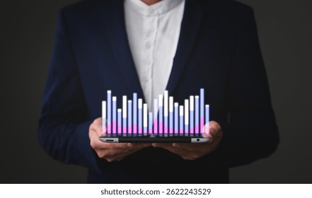 A person in a suit holds a tablet displaying a colorful 3D bar graph, symbolizing data analysis and business growth. - Powered by Shutterstock - Get 15% off with code: PIKWIZARD15