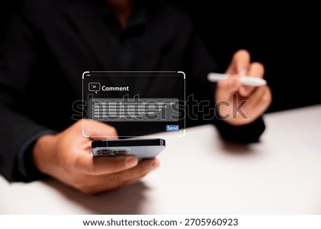 A person in a suit is using a smartphone, preparing to send a comment, with a digital text box displayed above the phone.