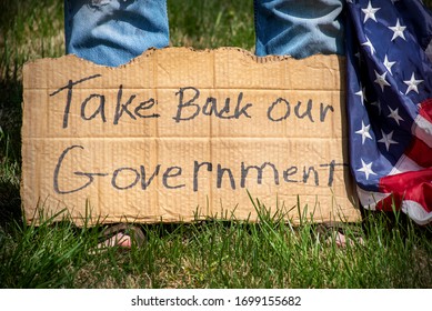 Person With Take Back Our Government Protest Cardboard Sign With American Flag, Wearing Jeans And Sandals, Radical, Conservative, Political Party, Revolution, 