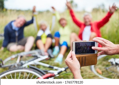 Person takes photos with the smartphone from the senior group on bike ride - Shutterstock ID 1765778120
