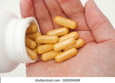 Person taking Boswellia capsules out of a bottle. Close up.