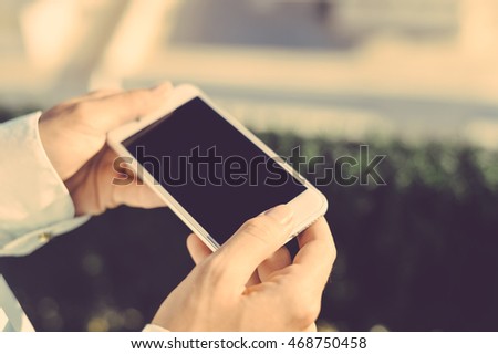 Person taking photo of city panorama on mobile smartphone, sunny day background