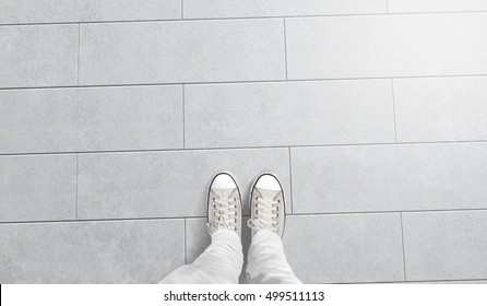 Person taking photo of his feet stand on blank floor, isolated, top view, clipping path. Ground design mock up. Man wear gumshoes and watching down. Deck flooring mockup template.