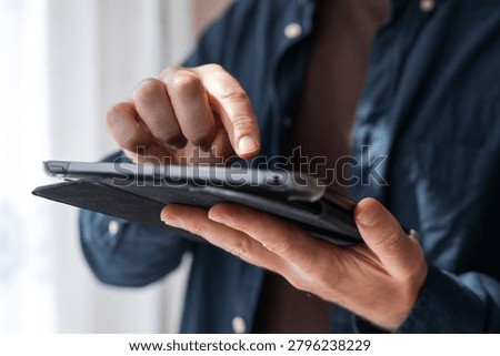 Person tapping a tablet touchscreen in a folio case for app interaction, user interface demo and tutorial background for digital design.