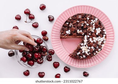 Person tasting chocolate and cherry cake - Shutterstock ID 2311022767