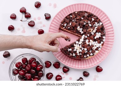 Person tasting chocolate and cherry cake - Shutterstock ID 2311022769