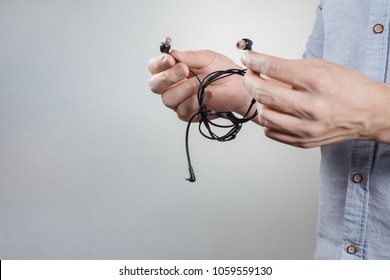 Person Trying To Untangle Headphone Wires On White Background