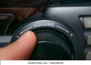 A Person Turning The Volume Wheel Up Or Down (the Focus Is On The Word 