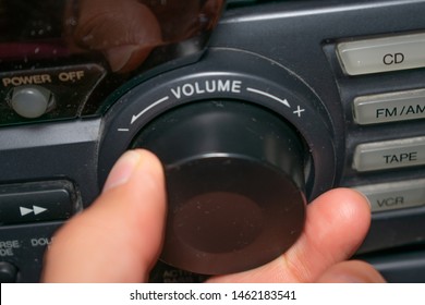 A Person Turning The Volume Wheel Up Or Down (the Focus Is On The Word 