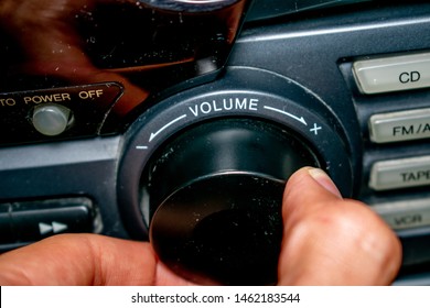 A Person Turning The Volume Wheel Up Or Down (the Focus Is On The Word 