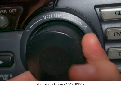 A Person Turning The Volume Wheel Up Or Down (the Focus Is On The Word 